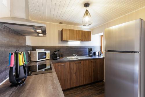 a kitchen with a stainless steel refrigerator and a microwave at la casse deserte in Arvieux