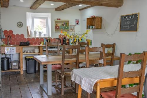 a dining room with tables and chairs and a chalkboard at Chambre indépendante n2 - Bretzel et Bergamote in Richtolsheim