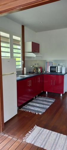 a kitchen with red cabinets and a white refrigerator at Kaz'a fred in Guenouillet