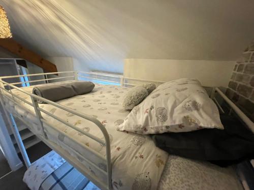 a bed with pillows on it in a room at Cosy 2 bedroom cottage in Llanuwchllyn