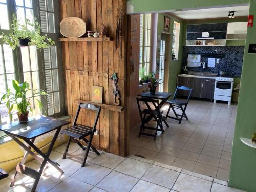 a kitchen with four chairs and a table in a room at Hostel do Lucca in Porto Alegre