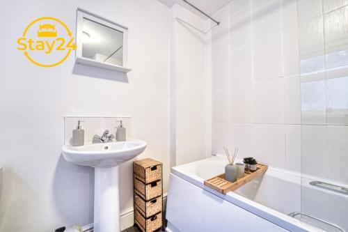 a white bathroom with a sink and a bath tub at Mill House Manor in Crewe