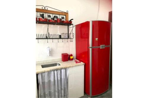 een rode koelkast in een keuken met een wastafel bij Cantinho do Sossego in Caraguatatuba
