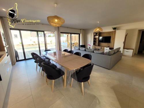 une salle à manger et un salon avec une table et des chaises dans l'établissement Villa Plein pied 8 pers piscine chauffée privée proche plage San Cipriano Cala Rossa Climatisation WIFI, à Lecci
