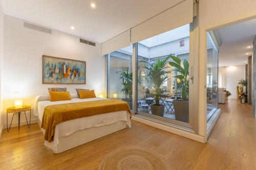 a bedroom with a bed and a large window at Apartamento de lujo en Calle Gravina in Seville