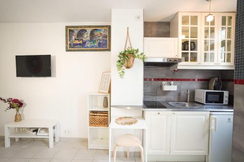 une cuisine avec des armoires blanches et un évier dans l'établissement Studio cosy hypercentre proche Vieux-Port et métro, à Marseille