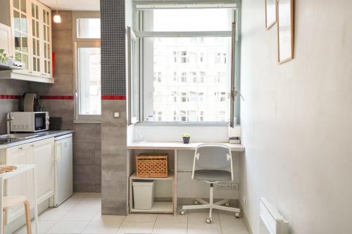 Elle comprend une petite cuisine avec un bureau et une fenêtre. dans l'établissement Studio cosy hypercentre proche Vieux-Port et métro, à Marseille