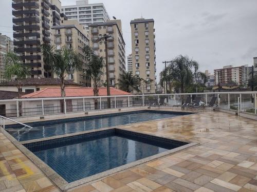 a large swimming pool in a city with tall buildings at Apto150 m praia piscina Wi-Fi 6pessoas in Praia Grande