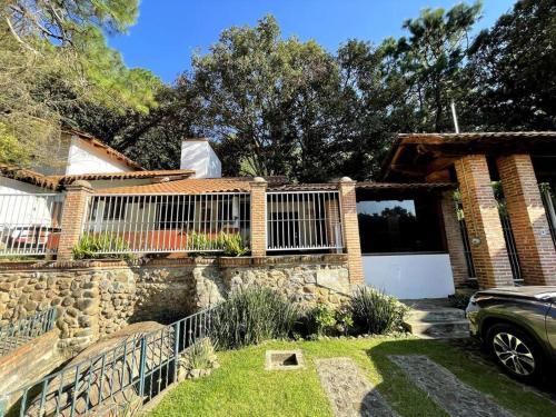 una casa de ladrillo con valla y entrada en Cabaña la Toscana en Mazamitla
