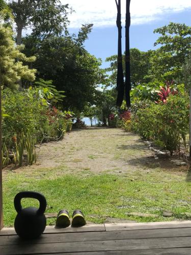 a pair of shoes sitting on a porch with a vase at Casa Kumbaya Costa Rica in Cabo Matapalo