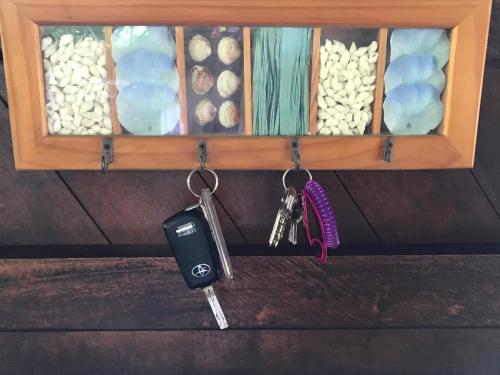 a pair of keys and a cell phone hanging from a shelf at Casa Kumbaya Costa Rica in Cabo Matapalo