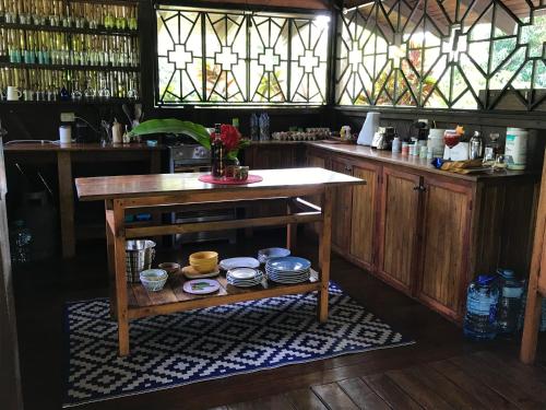 a kitchen with a table and a counter with glasses at Casa Kumbaya Costa Rica in Cabo Matapalo