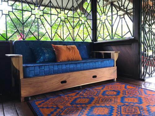 a blue couch in a room with a window at Casa Kumbaya Costa Rica in Cabo Matapalo