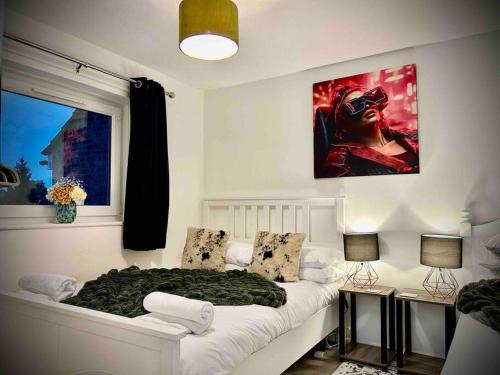 a bedroom with a bed and a painting on the wall at 2 Bedroom House -Sleeps 7- Big Savings On Long Stays! in Canterbury