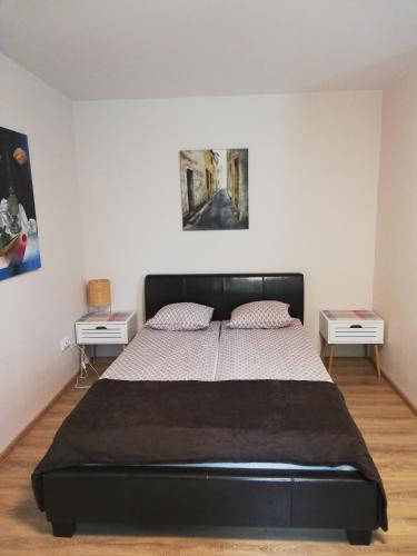 ein Schlafzimmer mit einem schwarzen Bett und zwei Tischen in der Unterkunft Gallery in Narva