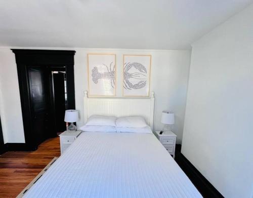 a bedroom with a large white bed with two lamps at Romantic West End Apartment with Parking in Portland
