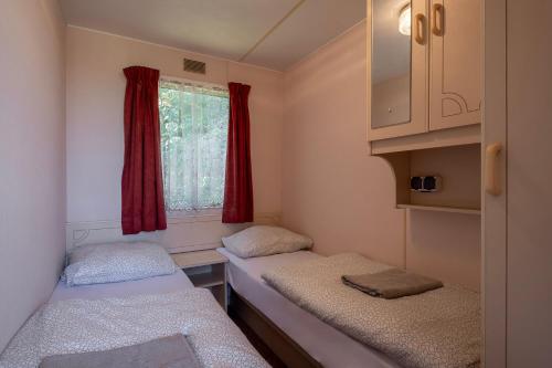 a small room with two beds and a window at 4 Pory Roku Apartamenty Domki Pokoje in Nadole