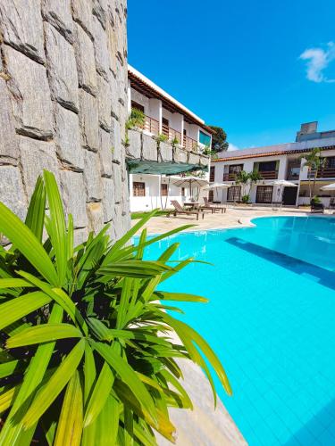 a swimming pool in front of a building at Estação do Sol Praia Hotel in Porto De Galinhas