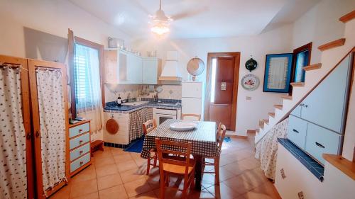 uma cozinha com mesa e cadeiras num quarto em Cortile Via San Simone Marettimo em Marettimo