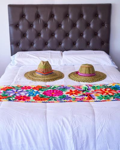 two hats on top of a bed with a blanket at Mojsa titicaca lodge in Puno