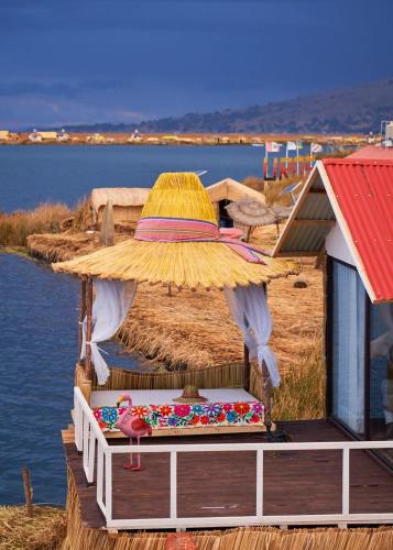 a large umbrella sitting on a dock next to the water at Mojsa titicaca lodge in Puno