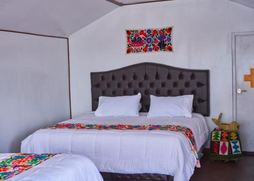 a bedroom with a large bed with a large headboard at Mojsa titicaca lodge in Puno