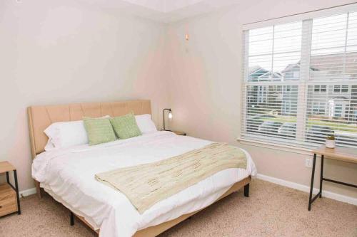 Un dormitorio con una cama grande y una ventana en Spacious Zionsville 1BR w/Balcony, en Zionsville