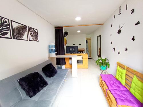 a living room with a couch and a clock on the wall at Osimiri apartamento Naturaleza y aventura in San Rafael