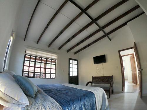 1 dormitorio con 1 cama con edredón azul en Mi terrunio-Alojamiento rural, en Duitama