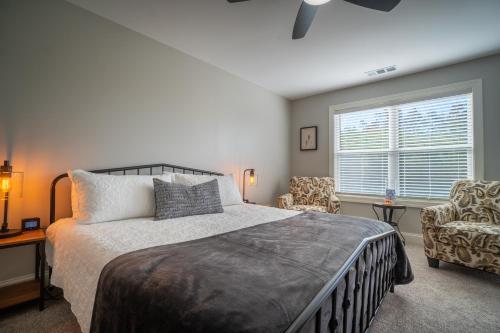 a bedroom with a bed and a chair and a window at Par-Tee Haus I- Game Room & Hot Tub-Walk to Helen in Helen