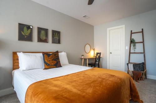 a bedroom with a bed with an orange blanket on it at Par-Tee Haus I- Game Room & Hot Tub-Walk to Helen in Helen