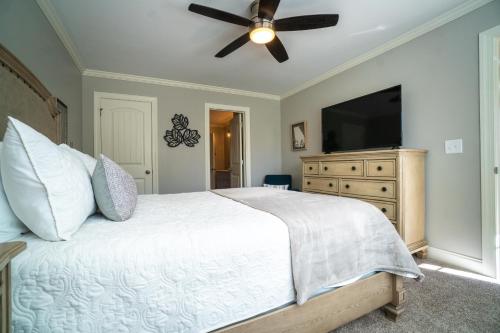 a bedroom with a bed with a ceiling fan and a television at Par-Tee Haus I- Game Room & Hot Tub-Walk to Helen in Helen