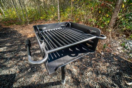 a black barbecue grill sitting in the dirt at Par-Tee Haus I- Game Room & Hot Tub-Walk to Helen in Helen