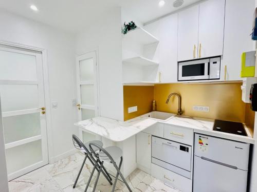 a kitchen with white cabinets and a sink and a microwave at Paris rare pearl 5e Notre Dame Saint Michel in Paris