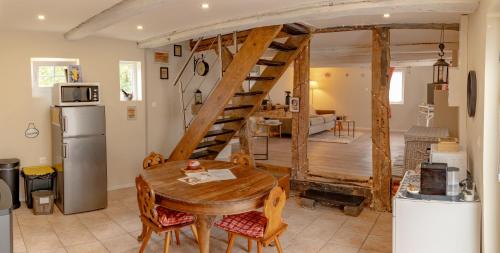 eine Küche und ein Esszimmer mit einer hölzernen Wendeltreppe in der Unterkunft Gîte indépendant - Bretzel et Bergamote in Richtolsheim