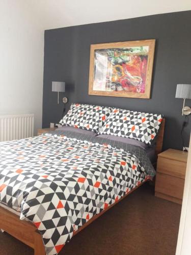 a bedroom with a bed with a black and white comforter at Reid's Hall in Hilltown