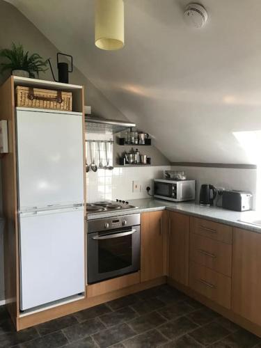 a kitchen with a white refrigerator and a stove at Reid's Hall in Hilltown