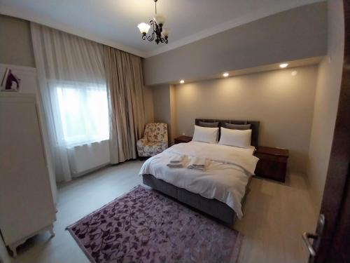 a bedroom with a bed and a chair and a window at Beautiful stone guesthouse in cool Konak district in Konak