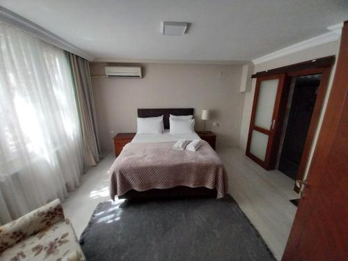 a hotel room with a bed and a large window at Beautiful stone guesthouse in cool Konak district in Konak