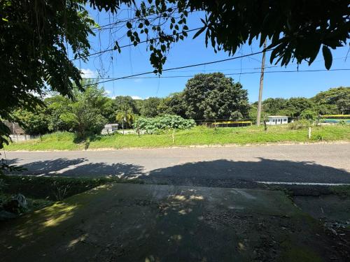 an empty street with a large shadow on the road at El mangal B&B in Suchitoto