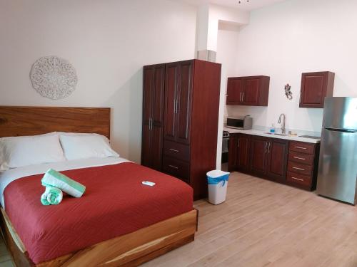 a bedroom with a bed and a kitchen with a refrigerator at Palm Beach Inn in Playa Grande
