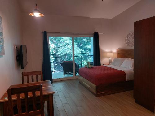 a bedroom with a bed and a large window at Palm Beach Inn in Playa Grande