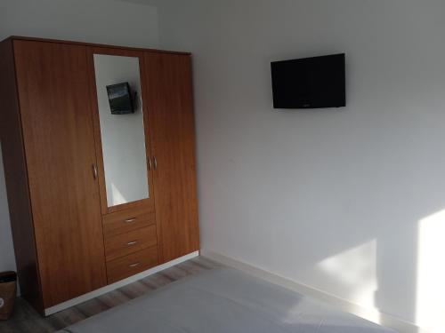 een kamer met een deur en een televisie aan een muur bij Vora Port in L'Ampolla