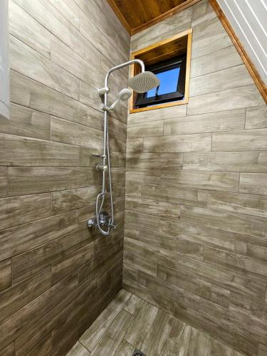 a shower stall in a bathroom with a window at B&B Cottage in Mestia in Mestia