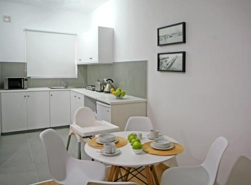 a kitchen with a table and white chairs in a room at Corina Suites & Apartments in Limassol