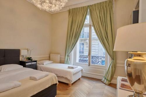 a hotel room with two beds and a window at Glamorous Apartment, excellent location in Paris