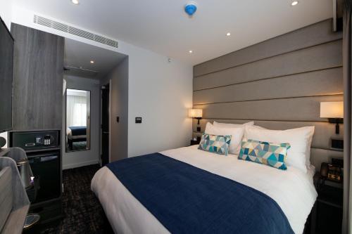 una camera d'albergo con un grande letto e una TV di Signature London, The J Marylebone a Londra