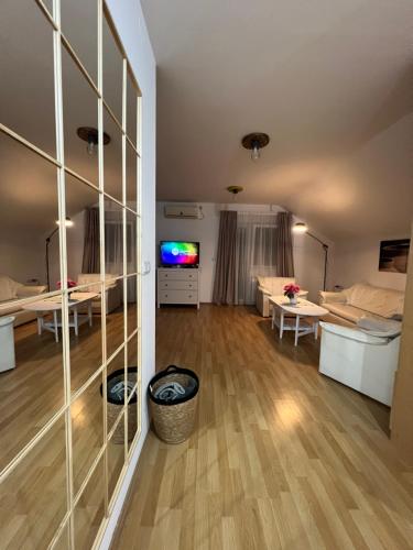 un salon avec une grande paroi en verre dans l'établissement Apartman Magnolija, à Zemun