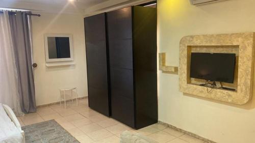 a living room with a television and a black cabinet at 1 bedroom first in Amman