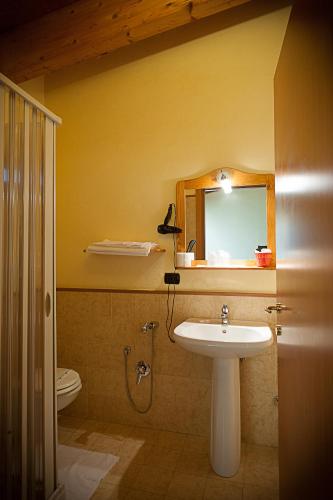 a bathroom with a sink and a toilet and a mirror at Albergo Tripoli B&B Affittacamere in Corato